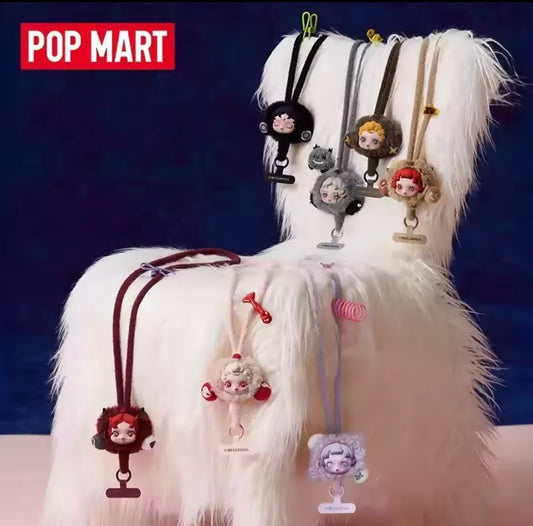 White fluffy chair with various character keychains attached, featuring the Pop Mart brand, skull panda