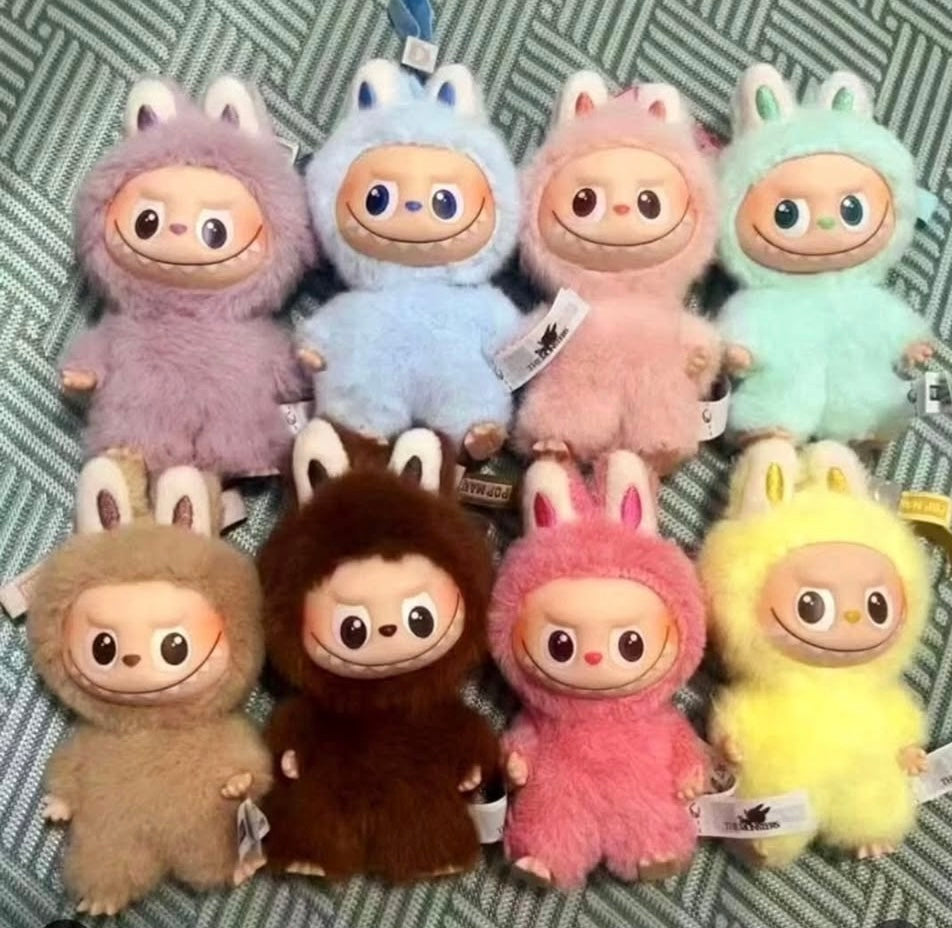 Set of colorful plush toys with animal-like designs on a patterned background, Labubu mini bag charm Pop Mart