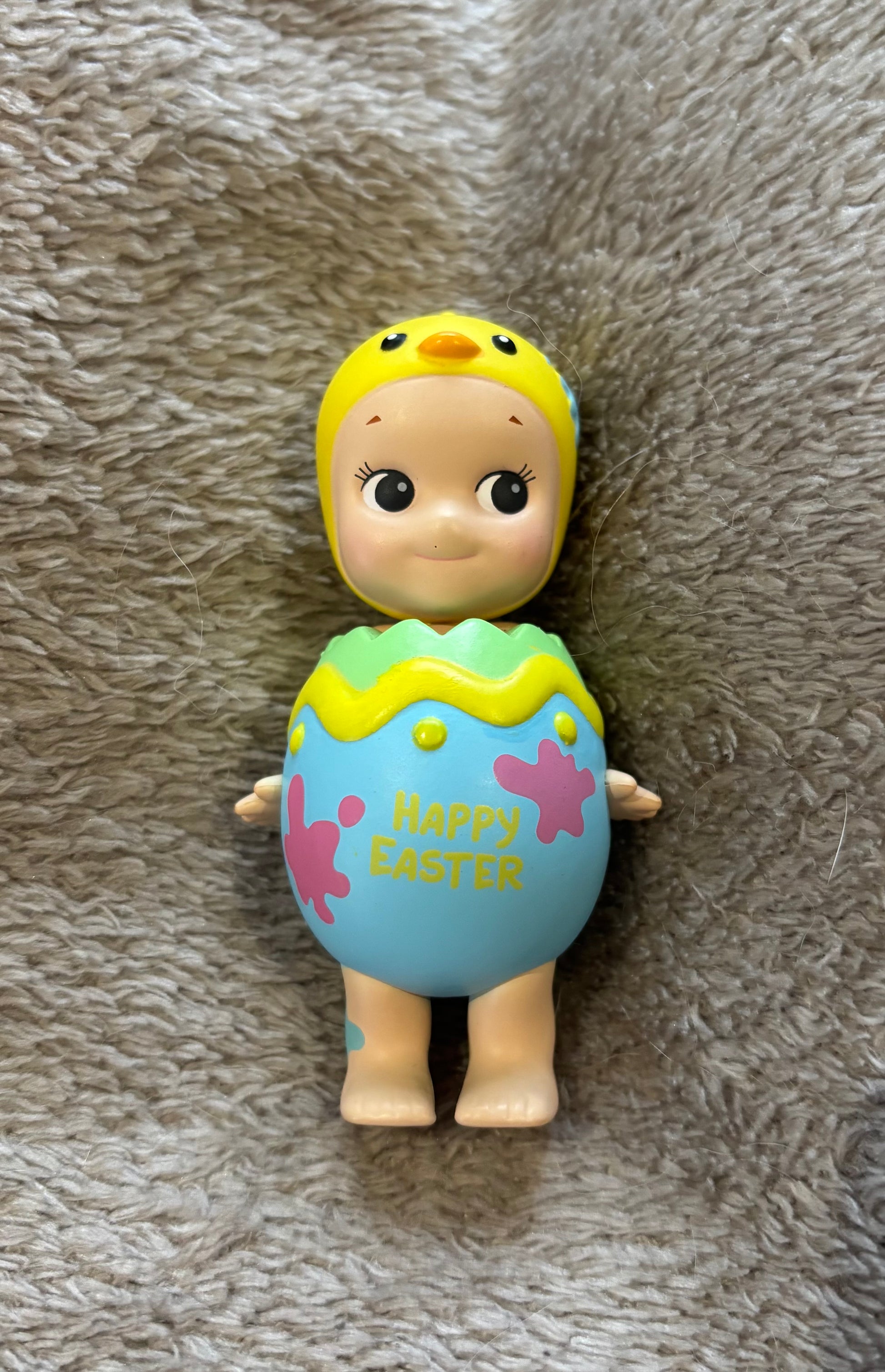 Cute rare Sonny Angel Easter Egg Easter Series mini figure yellow and blue lying on grey blanket