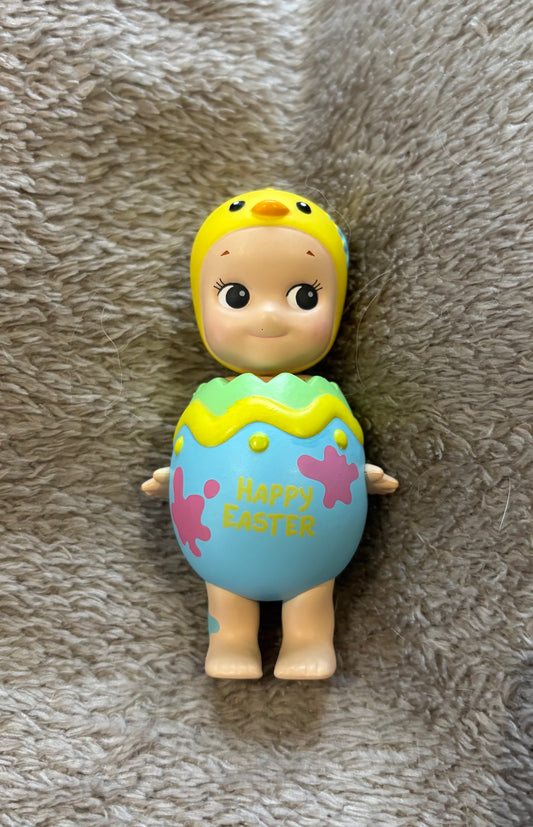 Cute rare Sonny Angel Easter Egg Easter Series mini figure yellow and blue lying on grey blanket