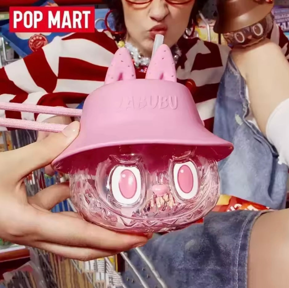 POP MART The Monsters Labubu Pink Tumbler held by hand with woman in background 
