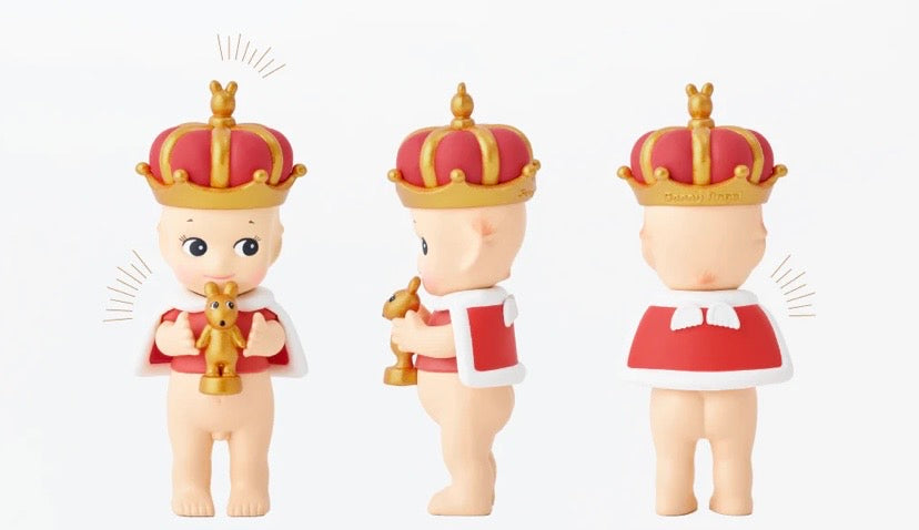 Three sonny angel garnet congratulations figurines wearing crowns on a white background