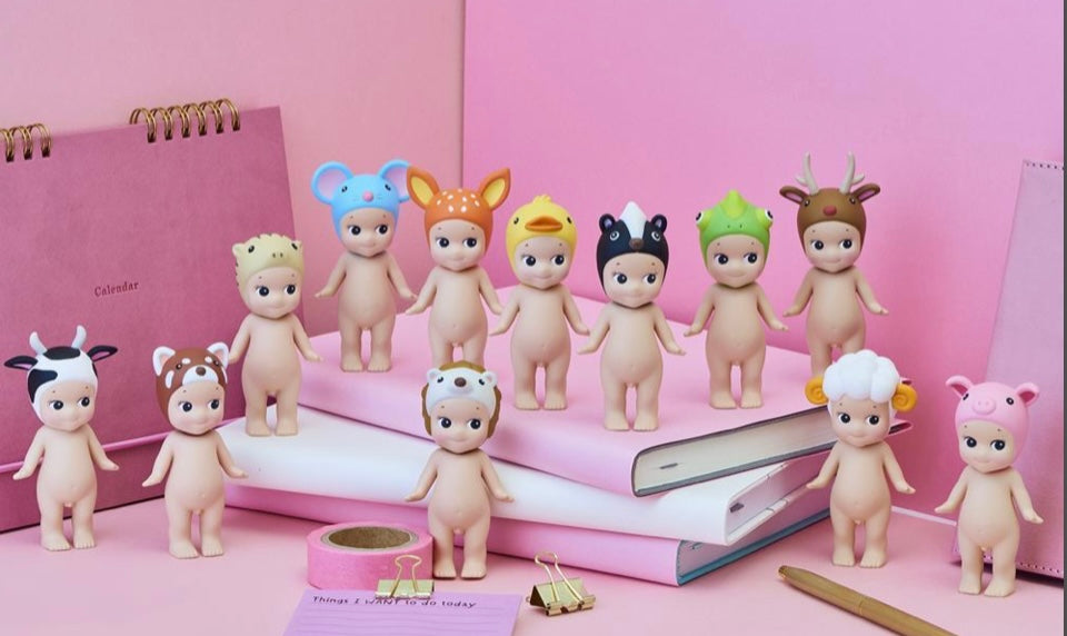 Set of small Sonny Angel figurines with animal head gear  on a pink background from animal series V2